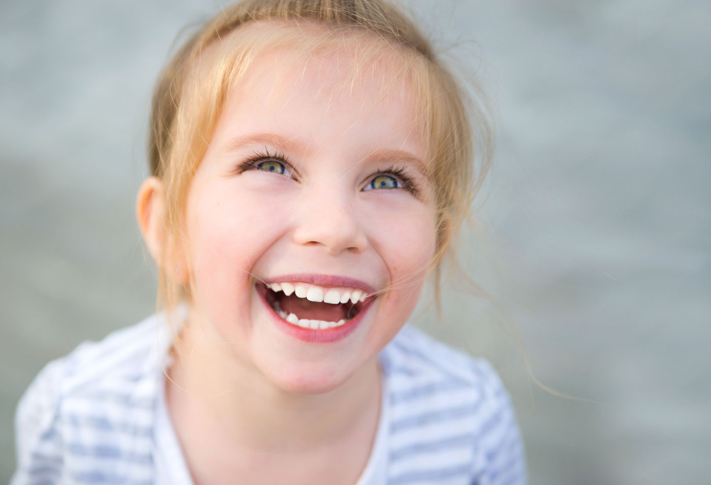 A young girl smiling showing her healthy teeth.
